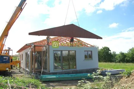 Montáž modulového betonového domu s kranem na staveništi.