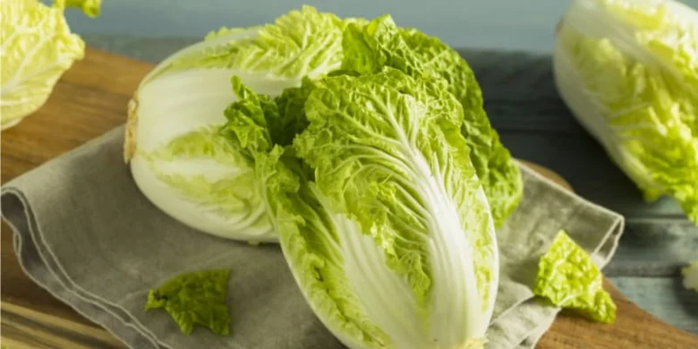 Čerstvé polovičky pekingského zelí na dřevěném prknu.