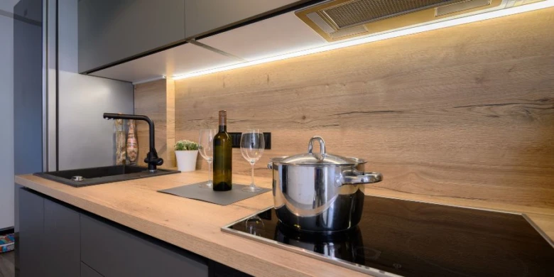 Moderní kuchyňská pracovní deska z dřeva s indukční varnou deskou.