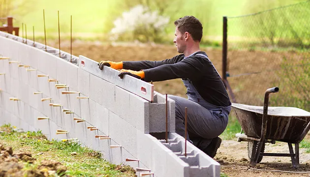 Práce s výztuží v betonových blokách při stavbě zdi