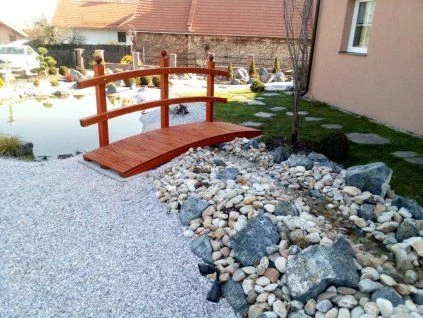 Hotová dřevěná lávka přes jezírko v zahradě