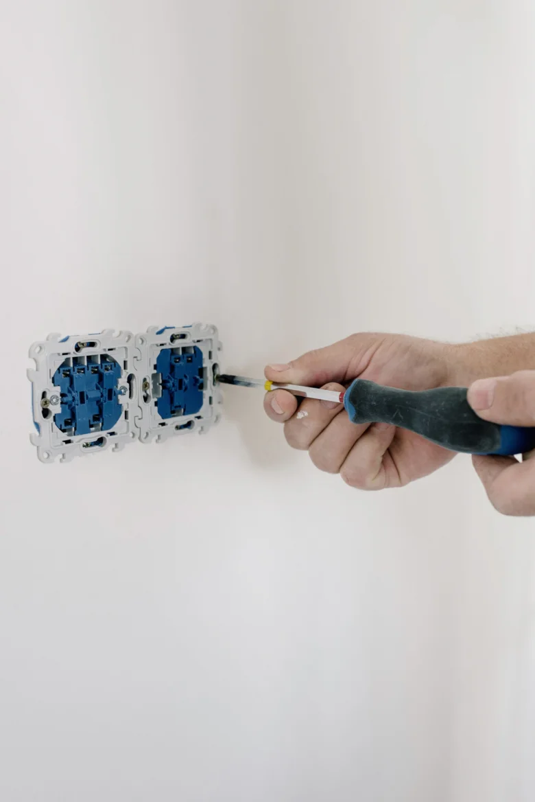 Instalace elektrické zásuvky šroubovákem na bílou zeď