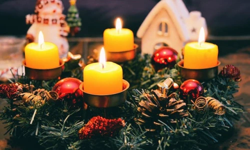 Zapálený adventní věnec s ozdobami pro první neděli adventní.