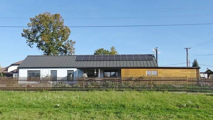Modern venkovský dům s fotovoltaickými panely na střeše.