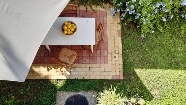 Hotová vyvýšená terasa s jídelním stolem v zahradě.