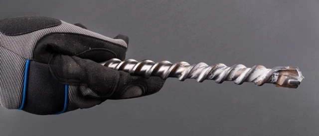 Drill bit držený v ruce s rukavice