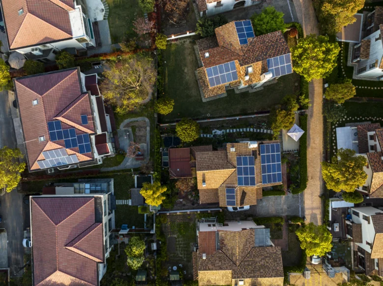 Vzdušný pohled na domy s fotovoltaickými panely.