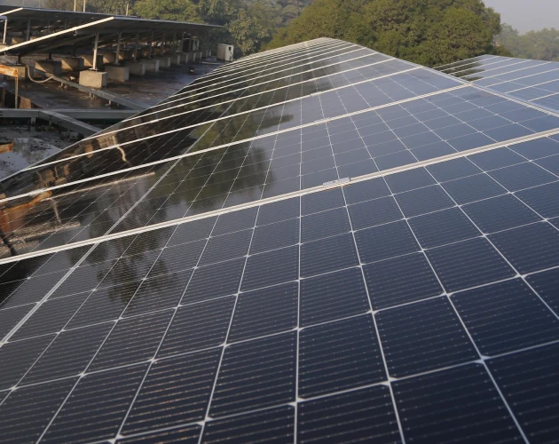 Čisté fotovoltaické panely na střeše průmyslového objektu.