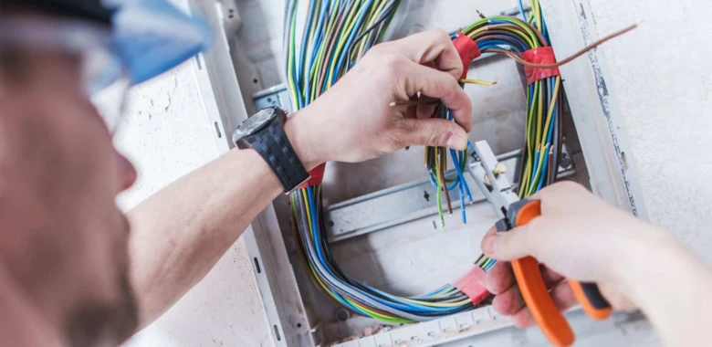Elektrikář opravuje domácí elektroinstalaci v rozvaděči.