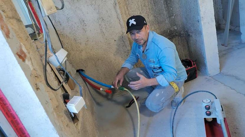Technik provádí tlakovou zkoušku topeni s připojeným zařízením.