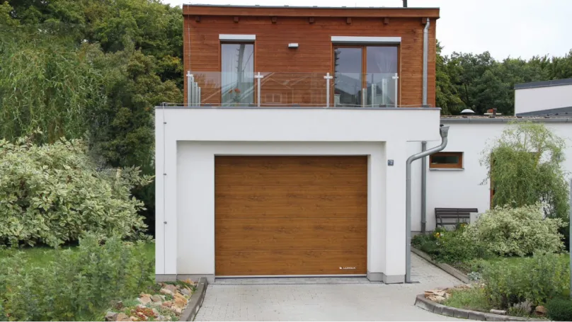 Dřevěná garážová vrata v moderním domě s balkónem.