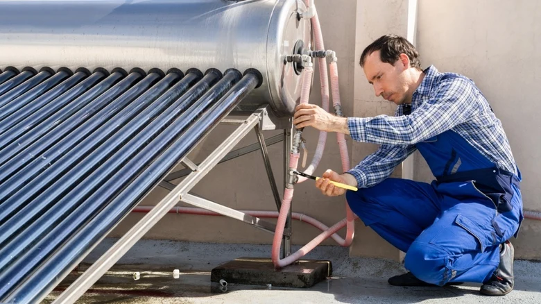 Technik opravuje solární ohřev vody