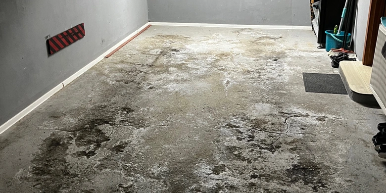 Poškozená betonová podlaha v garáži před opravou