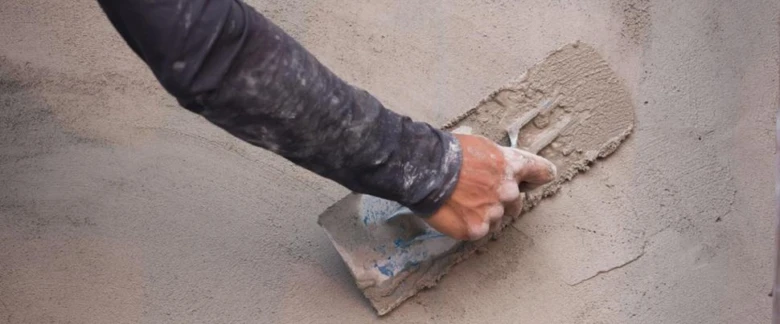Ruční úprava povrchu venkovního betonu špachtlí.