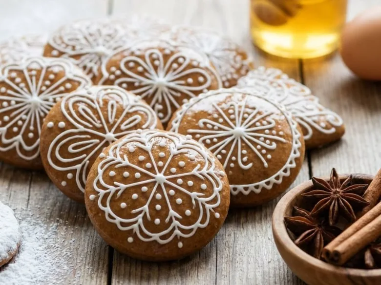 Tradiční české perníky s bílým cukrovím na dřevěném povrchu.