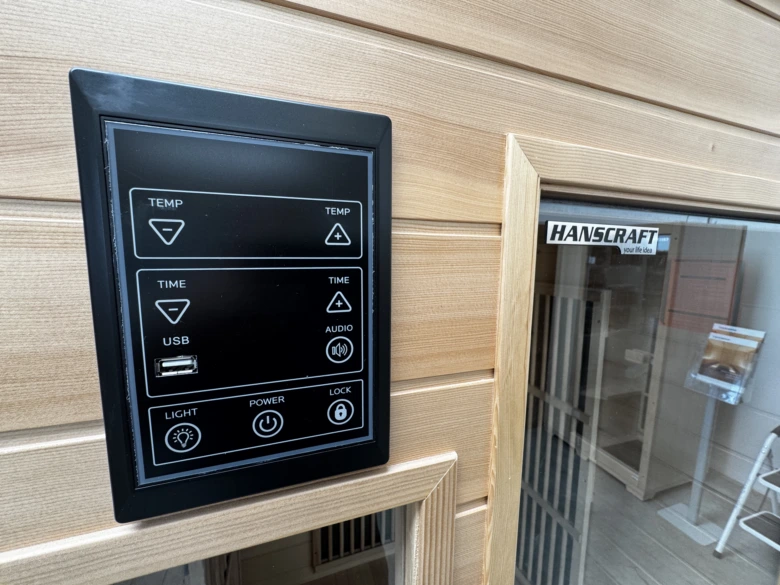 Ovládací panel infrasauny s tlačítky pro nastavení teploty a času.