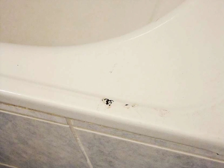 Poškozená smaltovaná vana s odškrábáním povrchu