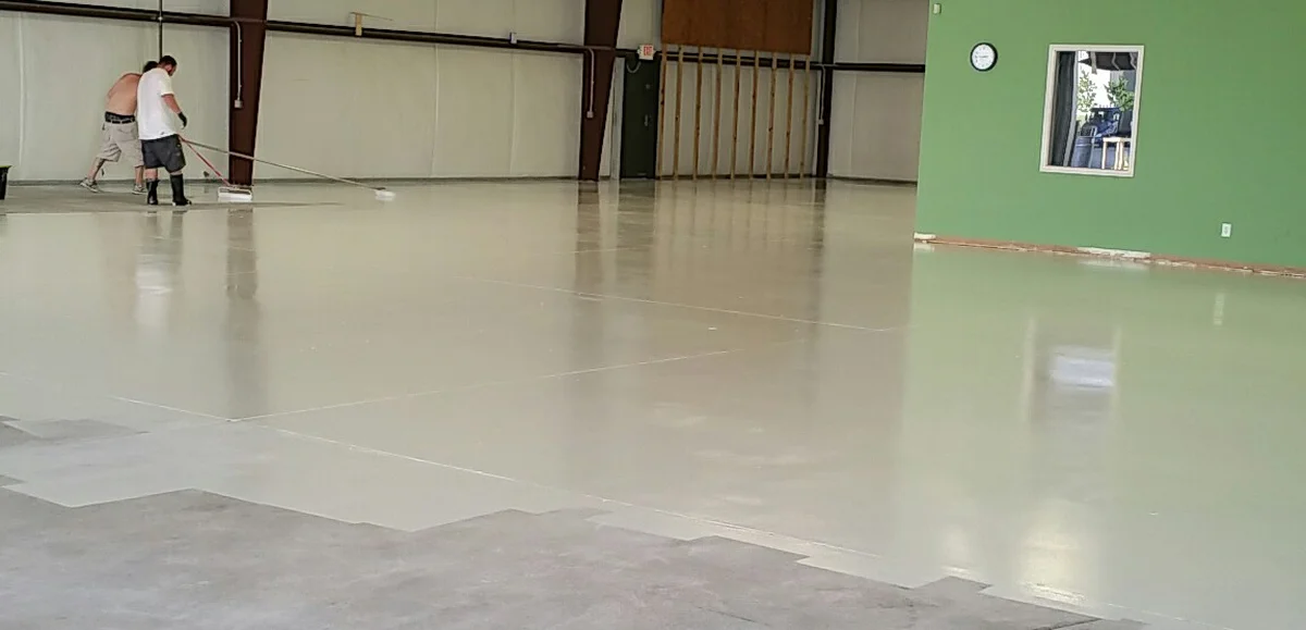 Práce na povrchové úpravě betonu v hale