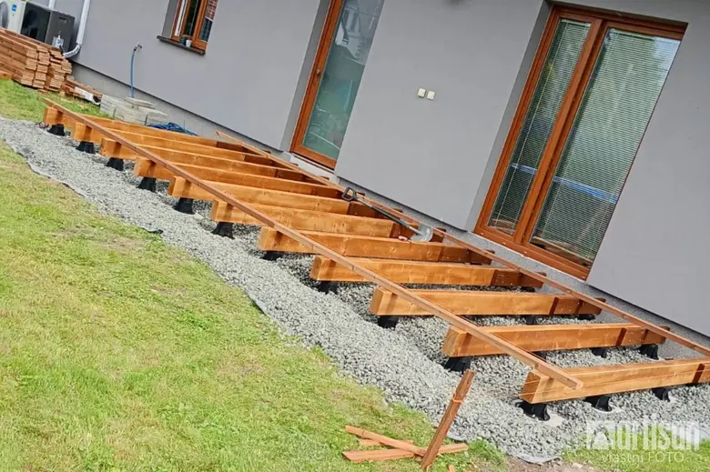 Dřevěné nosníky terasy na základně z kámen