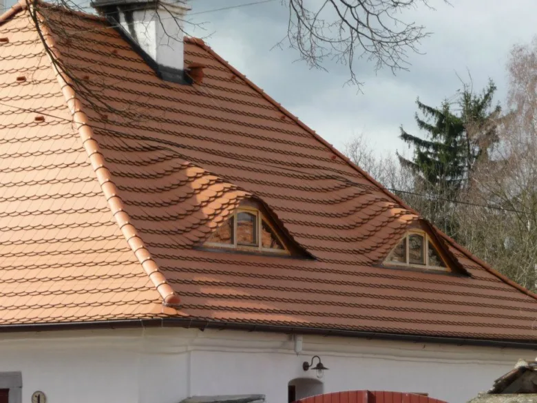 Přestavba starého domu s novou střechou a okny.