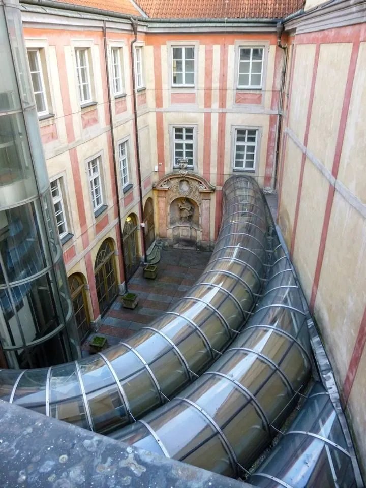 Dvůr domu u červené lišky s průchozím skleněným chodbou.