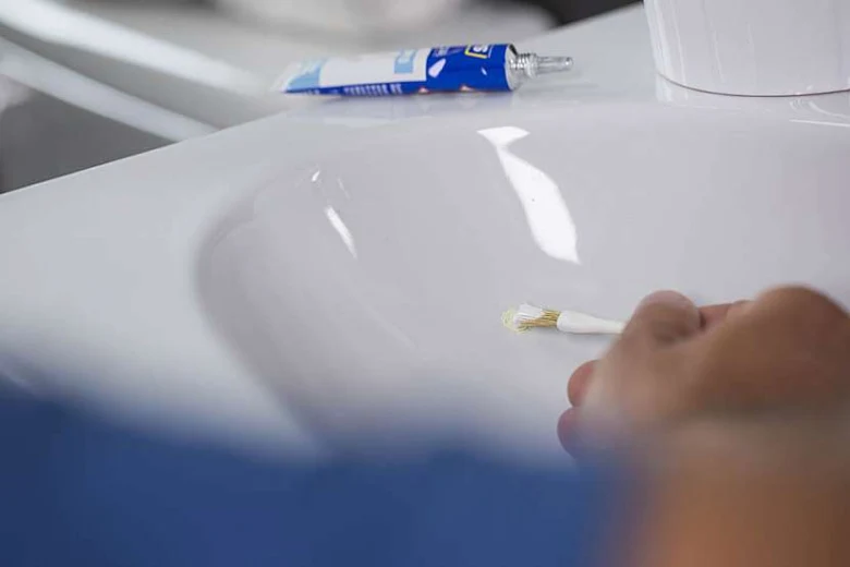 Oprava smaltované vany aplikací lepidla štětcem