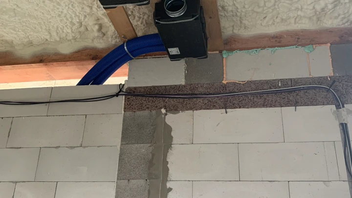 Instalace rekuperačních potrubí v stropu s izolací.