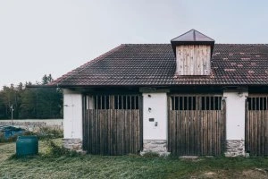 Stará stodola s dřevěnými dveřmi jako inspirace pro bydlení.
