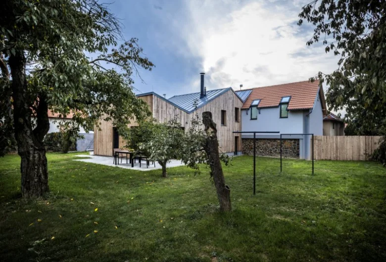 Moderní venkovský dům s dřevěnou fasádou v zahradě.