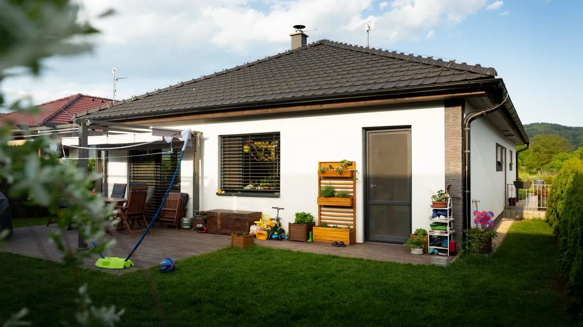 Venkovní terasa s dům a rostliny v květináčích.