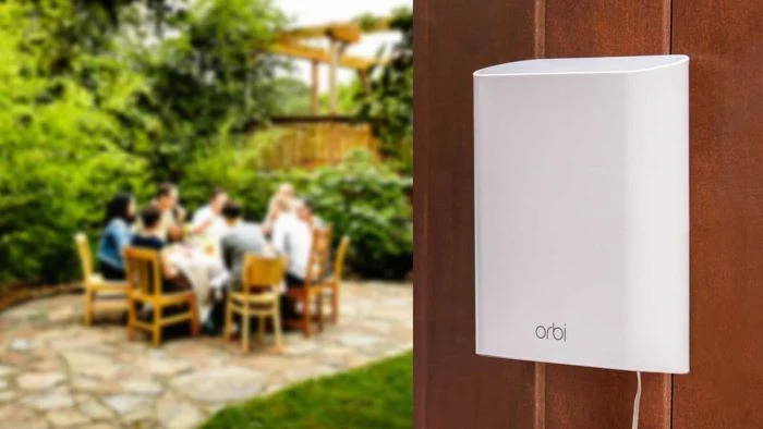 Bílý venkovní Wi-Fi rozšiřovač na plotu v zahradě