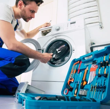 Technik opravuje pračku s nářadím v Praze