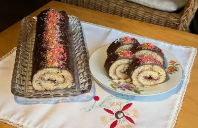 Kousky bezlepkového roládu s čokoládovou polevou na talíři.