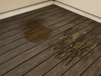 Poškozená dřevěná terasa s vlhkostí a plísní
