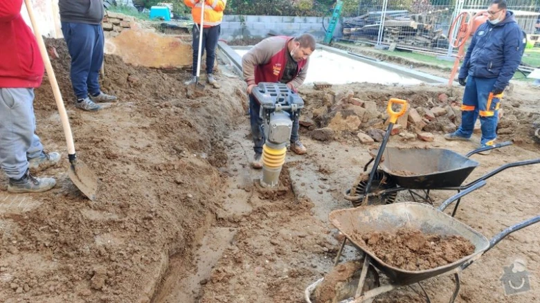Práce na venkovní dlažbě s použitím vibračního lisu.