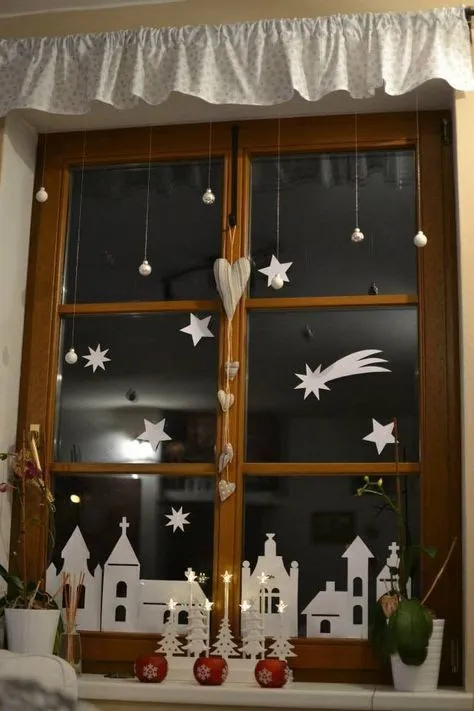Výzdoba okna na Vánoce s hvězdami a domy.