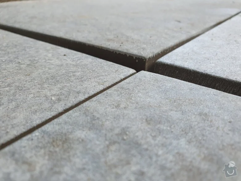 Betonová dlažba s viditelnými spárami na povrchu chodníku.