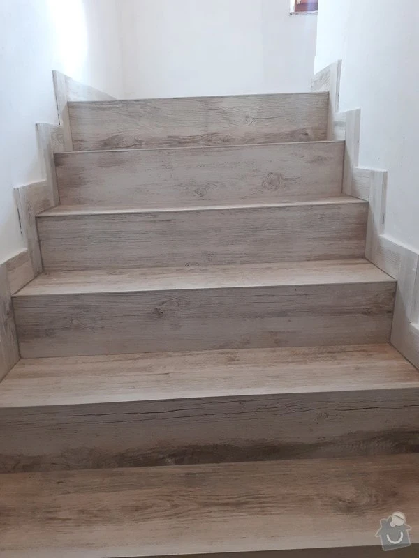 Opravené schody s dřevěným povrchem v interiéru.